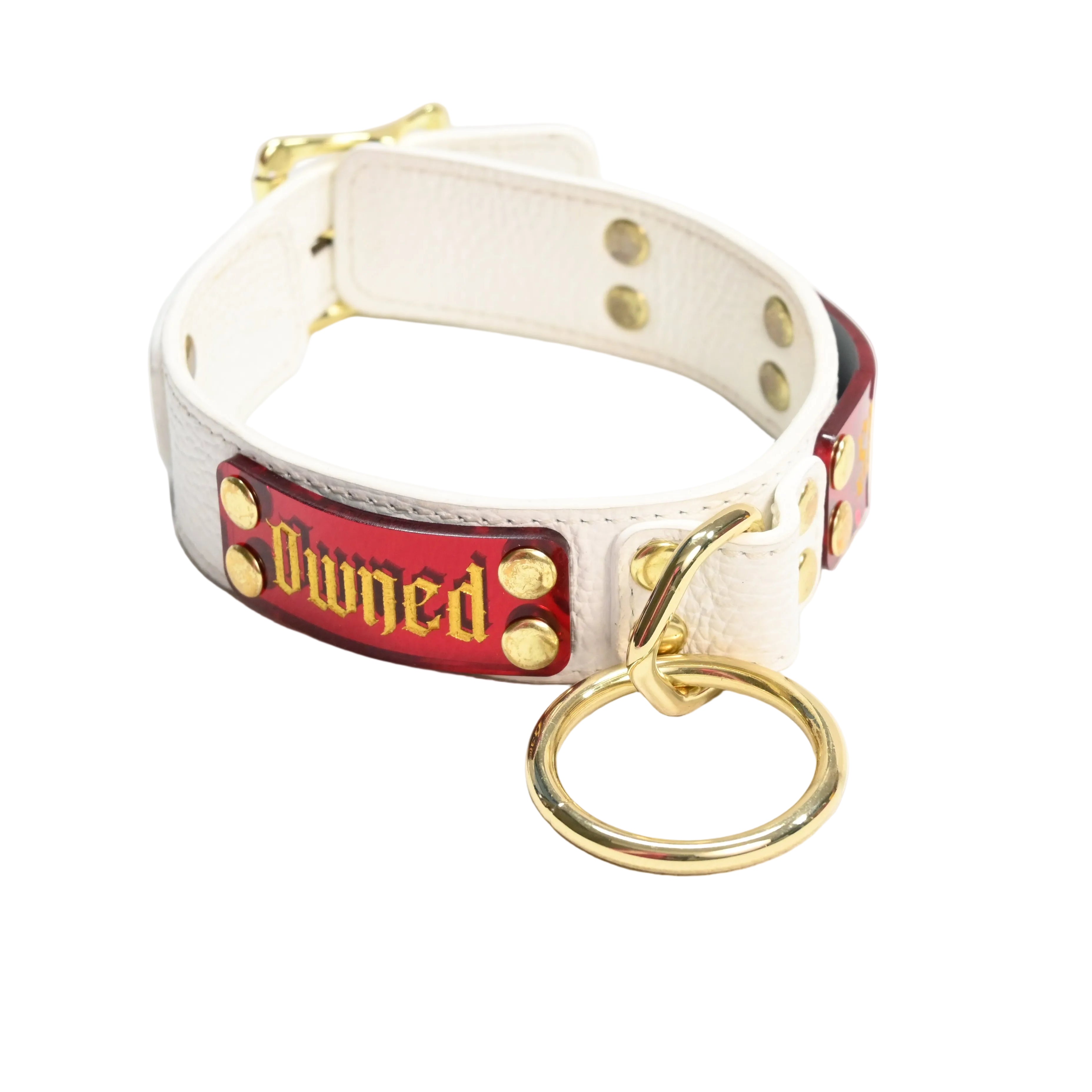 White leather collar with red nameplate featuring the word 'Owned' in a gold font with gold hardware on a white background.