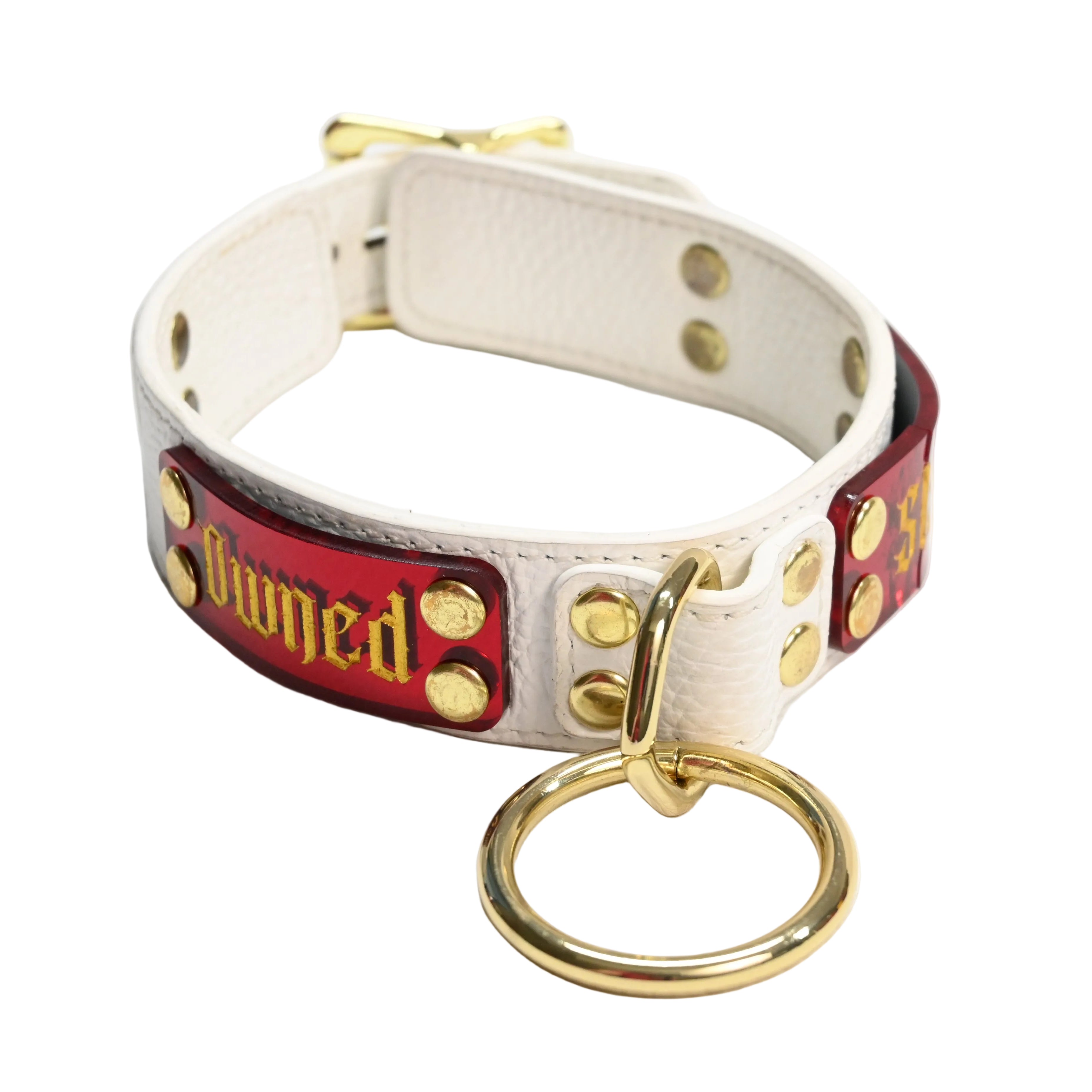 White leather collar with red nameplate featuring the word 'Owned' in a gold font with gold hardware on a white background.