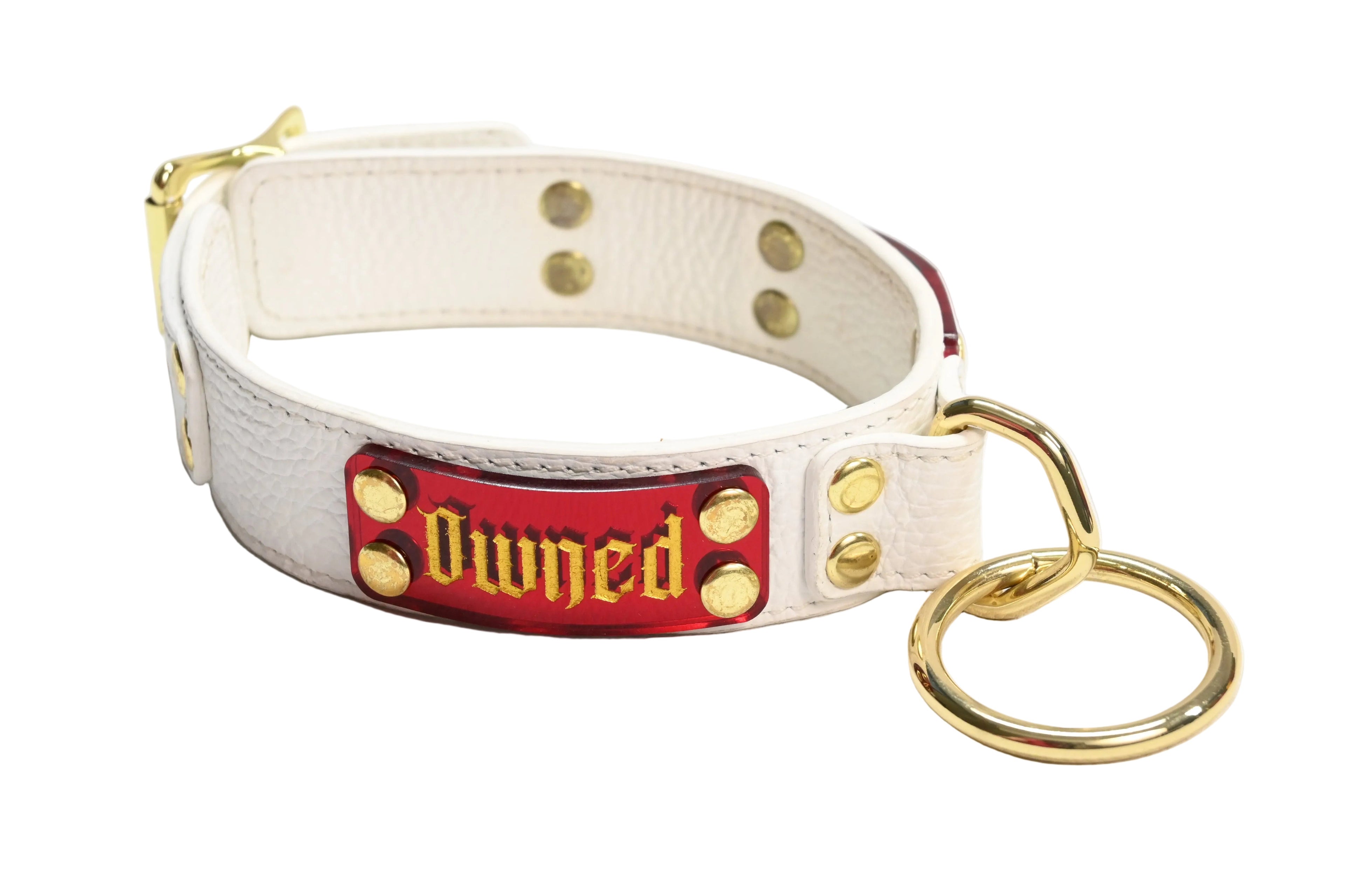White leather collar with red nameplate featuring the word 'Owned' in a gold font with gold hardware on a white background.