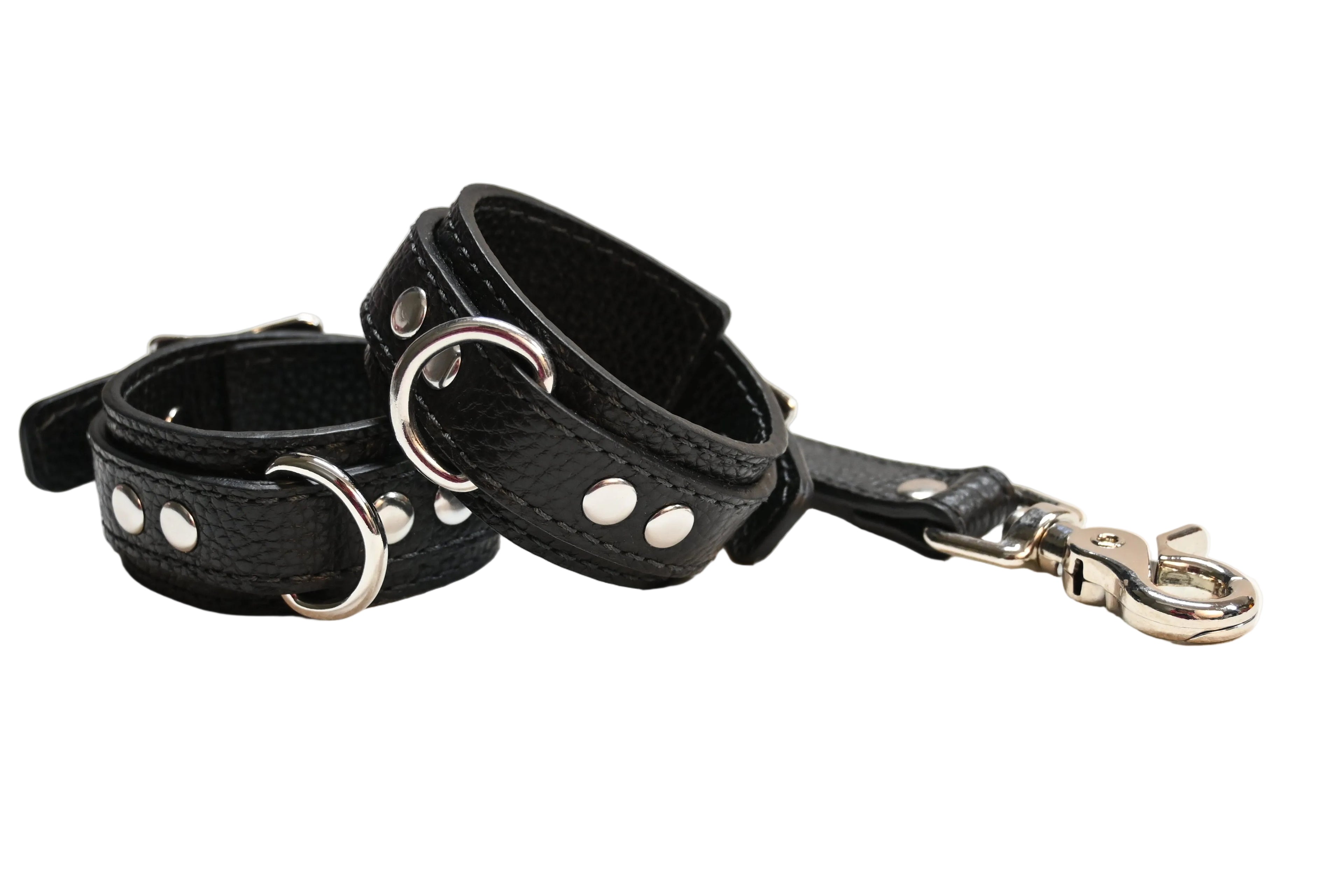 A black textured leather collar with silver-tone metal studs and D-rings, shown with its matching black leather link and silver snap hook clasp on a white background.