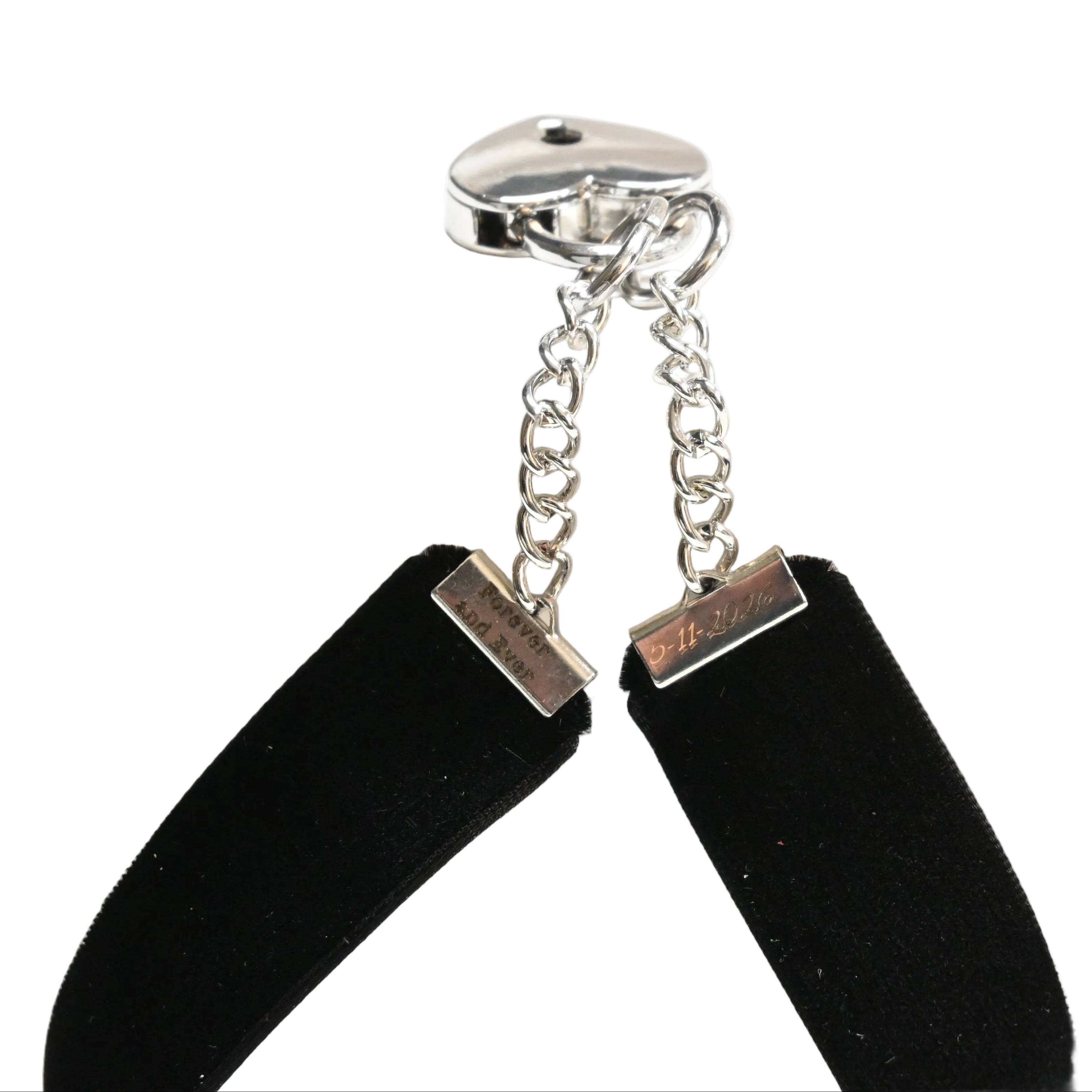 A close-up of a black velvet choker with silver metal hardware, including a silver clasp, chain, and rectangular connector, shown against a white background.